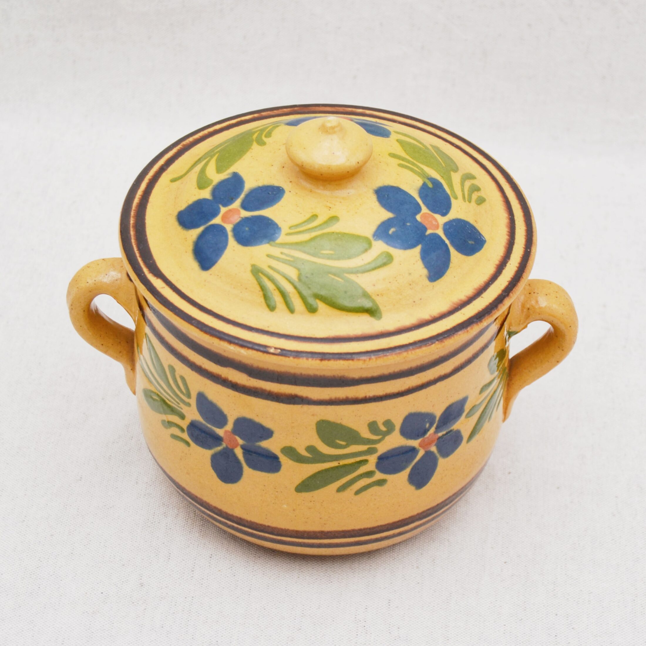 Le pot en céramique jaune à fleurs