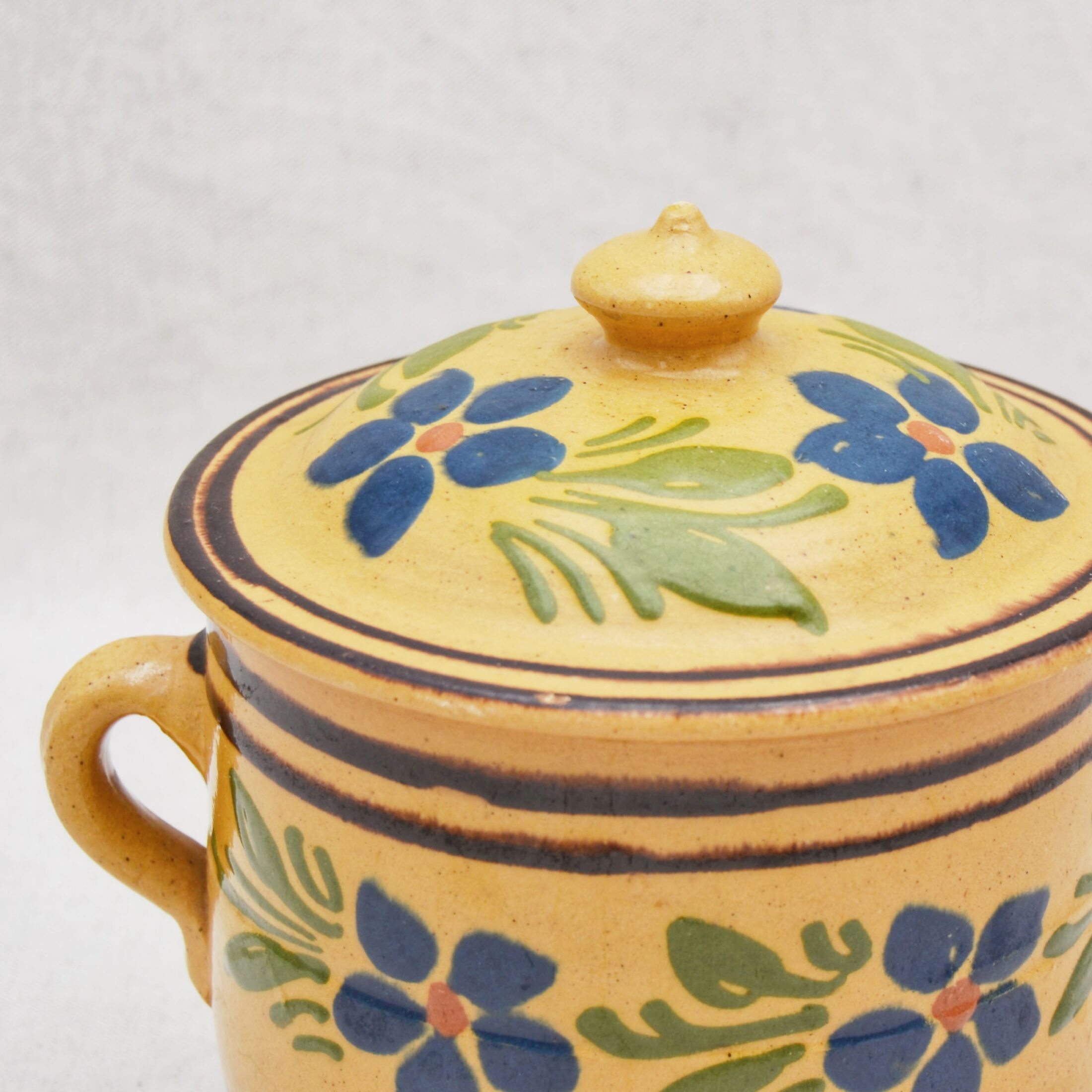 Le pot en céramique jaune à fleurs